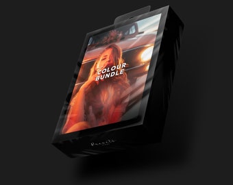 Puede incluir: Una caja negra con una cubierta de plástico transparente. La caja tiene el texto "COLOUR BUNDLE". La imagen dentro de la caja muestra a una mujer en un coche con un cálido resplandor naranja.