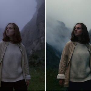 May include: A woman wearing a white jumper and a beige jacket stands in a foggy mountain landscape. The woman is looking up and to the right.