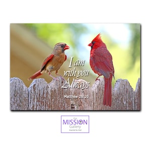 May include: Two red cardinals perched on a wooden fence with a green background. The text "I am with you Always" is written in white with the scripture reference "Matthew 28:20" below. The text "the MISSION Gallery inspired by God" is in a purple box at the bottom of the image.