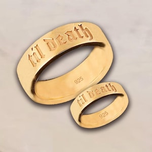 May include: Two gold-colored rings with the inscription "til death" in an old English font. The rings are made of 925 silver. The rings are a matching set, one larger than the other.