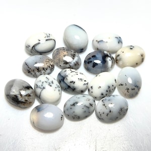 May include: A selection of oval dendritic opal gemstones. The opals are mainly white, featuring detailed black and grey patterns that resemble tree-like structures. The gemstones are polished, with a smooth, glossy surface.