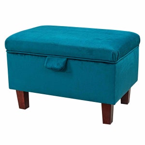 May include: Teal velvet storage ottoman with a hinged lid and wooden legs.
