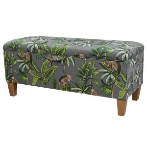 May include: A grey storage bench with a tropical print featuring monkeys and palm trees. The bench has wooden legs and a hinged lid.