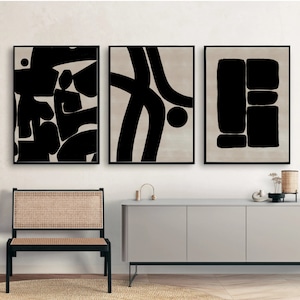 Pu&ograve; includere: Tre stampe d'arte astratta in bianco e nero con forme geometriche e linee. Le stampe sono incorniciate in nero e appese a una parete bianca sopra una cassettiera grigio chiaro.