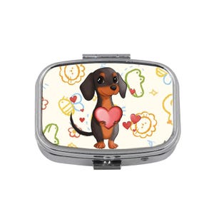 May include: A silver pill box with a cartoon dachshund holding a pink heart. The background is cream-colored with colorful doodles of flowers, bees, and hearts. The dachshund is brown and black.