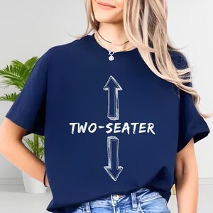 A woman wearing a navy blue t-shirt with a white graphic design on it.