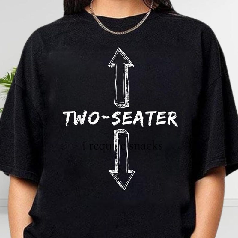 A black t-shirt with a graphic design featuring two arrows pointing upwards and the text "TWO-SEATER" below them.