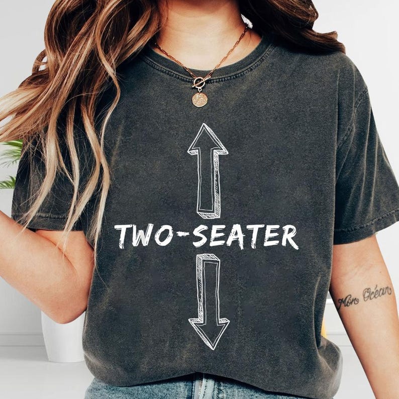 A person wearing a black t-shirt with a graphic design and text printed on it.