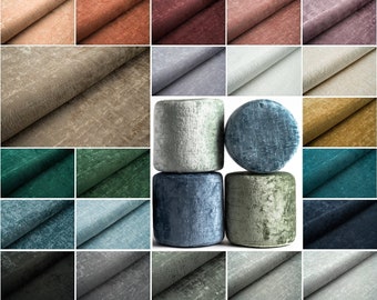 Op de afbeelding: Een verzameling stofstalen in verschillende kleuren en texturen, waaronder beige, bruin, groen, blauw en grijs. De stalen zijn in een rasterpatroon gerangschikt en worden weergegeven op een witte achtergrond.