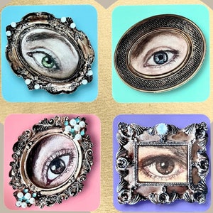 May include: Four ornate gold-toned frames with decorative details, each featuring a different eye with a unique color and design. The frames are set against a colorful background.