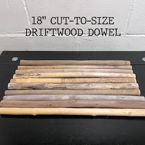 May include: An assortment of 18-inch cut-to-size driftwood dowels. The natural wood dowels vary in color from light tan to grey and brown. The text "18" CUT-TO-SIZE DRIFTWOOD DOWEL" is printed in black above the dowels.