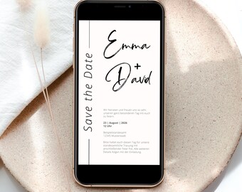 May include: A smartphone shows a wedding invitation with the names "Emma + David" in stylish script. The phone is on a beige plate, with a white cloth and dried flowers in the background. The invitation includes the text "Save the Date".