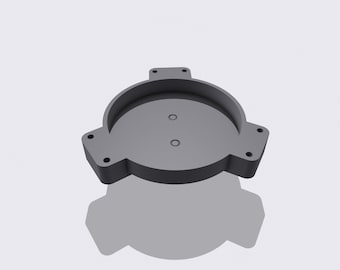 May include: A gray, circular, 3D-printed object with a raised rim and three rectangular tabs. Two small holes are visible in the center. The object is set against a white background.