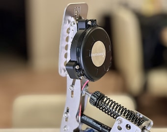 May include: A close-up of a silver and black racing pedal with a spring and a black motor with the text "HYSTERONIC" on it.