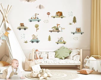 Op de afbeelding: Een set kleurrijke wanddecals met dierenmotieven, waarop verschillende dieren in auto's rijden. De decals bevatten een leeuw, een olifant, een giraffe en een beer. De decals zijn perfect om een kinderkamer een speelse touch te geven.