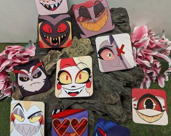 May include: Ten square coasters featuring cartoon characters with red, yellow, and black accents. The characters have different facial expressions and are set against a wood background.