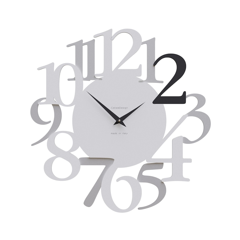May include: A modern wall clock with a white face and large, stylized numerals in a light gray color. The number "2" is black. The clock hands are black, and the text "CalliaDesign" and "made in italy" are visible.