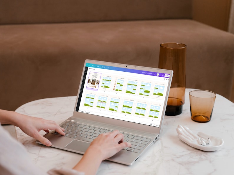 May include: A person using a laptop computer to design a social media post. The laptop screen shows a design template with a blue sky, green grass, and white clouds. The design template is for a social media post about "Sleeping Beauty".
