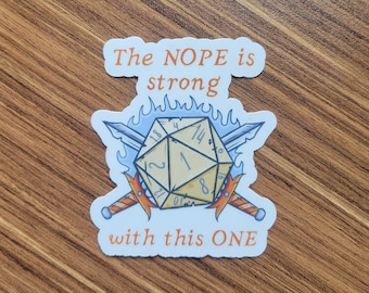 May include: A white sticker with a blue and orange design. The sticker features a 20-sided die with a 1 showing, crossed swords, and flames. The text "The NOPE is strong with this ONE" is printed on the sticker.