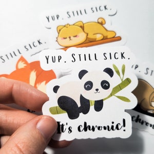 May include: A set of four stickers featuring cute cartoon animals with the text "Yup. Still Sick." and "It's chronic!" The stickers are printed on white paper with black outlines.