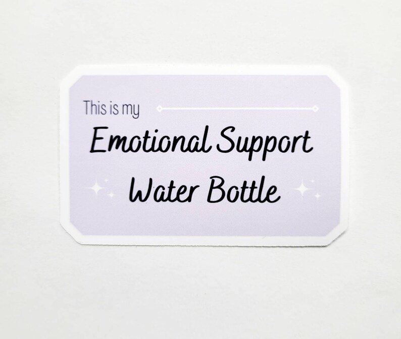 Peut inclure: Un autocollant lavande avec une bordure blanche et des coins arrondis. L'autocollant dit "This is my Emotional Support Water Bottle" avec deux petites &eacute;toiles blanches de chaque c&ocirc;t&eacute; du texte.