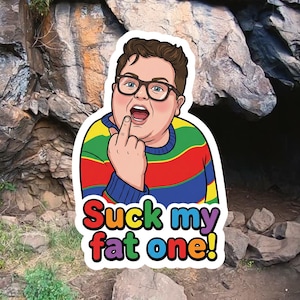May include: A sticker featuring a cartoon illustration of a person wearing glasses and a colorful striped sweater, giving the middle finger. The sticker has the text "Suck my fat one!" in a colorful font.