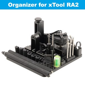 May include: Black organizer for xTool RA2 laser engraver with various tools and accessories, including a level, a rotary attachment, and a set of tools.