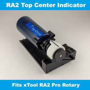Puede incluir: Un indicador de centro superior negro y azul para la fresadora rotativa xTool RA2 Pro. El indicador tiene una etiqueta blanca que dice "Top Center".