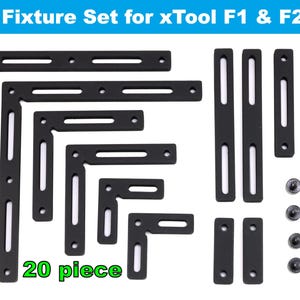 May include: A 20-piece fixture set for xTool F1 & F2 laser engravers. The set includes black metal brackets, plates, and screws. The text "Fixture Set for xTool F1 & F2" is at the top, and "20 piece" is at the bottom.