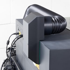 以下が含まれることがあります： 黒と灰色の機械で、背面に黒いフレキシブルホースが取り付けられています。ホースは、灰色のパネルが付いた黒い箱に接続されています。