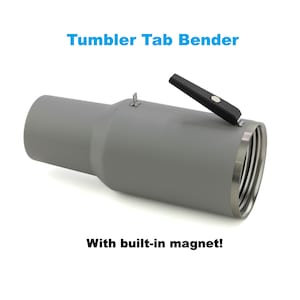 May include: A gray metal Tumbler Tab Bender with a black handle and a built-in magnet.  The tool is designed to bend tabs on tumblers.
