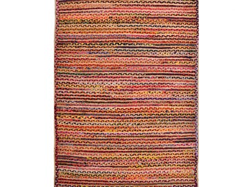 May include: Rectangular rug with a woven design. The rug features horizontal stripes in shades of red, orange, yellow, and brown. The rug's edges are a natural tan colour. The rug is made of a durable material.