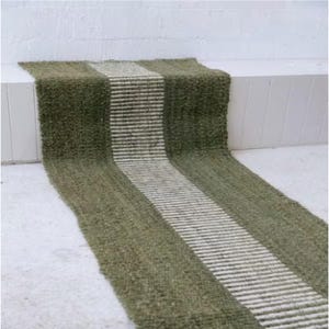 以下が含まれることがあります： 緑と白のストライプのジュート製の敷物で、織り込まれた質感があります。敷物は長く、狭く、廊下や玄関に最適です。