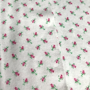 Baby pink rosebuds with light green stems in flannel. This is a 5 piece Baby Bundle, includes sheet set, Burp Cloth, Bib and Blanket