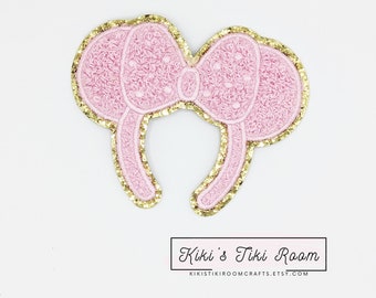 May include: Pink and gold embroidered Minnie Mouse ears headband with a bow. The bow has white polka dots.