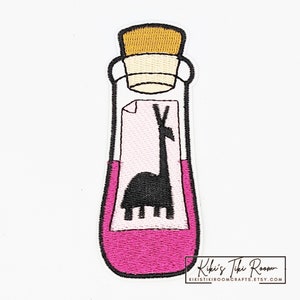 May include: Embroidered patch of a pink potion bottle with a cork stopper. Inside the bottle is a white piece of paper with a black llama silhouette. The text "Kiki's Tiki Room" is at the bottom of the patch.