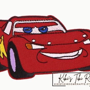 Peut inclure: Voiture de course rouge de dessin animé avec un visage souriant et un éclair jaune sur le côté. La voiture a des roues noires et un pare-brise blanc.