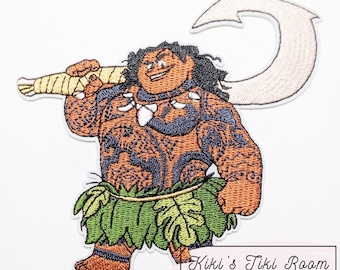 May include: Embroidered patch featuring a cartoon character with brown skin, tattoos, and a green leaf skirt. The character holds a large, curved hook and a wrapped staff. The patch has a white border and the text "Kiki's Tiki Room".