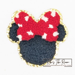 May include: Red and white polka dot bow with black ears and gold glitter trim.  The bow is a felt applique.  Kiki's Tiki Room, kikiistikicrafts.etsy.com