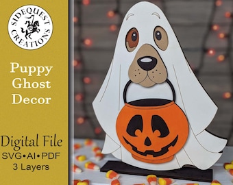May include: A white ghost with a brown puppy face holding a pumpkin-shaped trick-or-treat bucket. The ghost is standing on a black base with candy corn scattered around it. The text "Puppy Ghost Decor" is visible in the image.