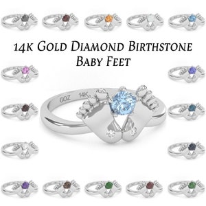May include: A collection of 14k gold baby feet rings with different birthstone colors. The rings feature a pair of tiny feet holding a gemstone in the center. The text "14K GOLD DIAMOND BIRTHSTONE BABY FEET" is displayed above the rings.