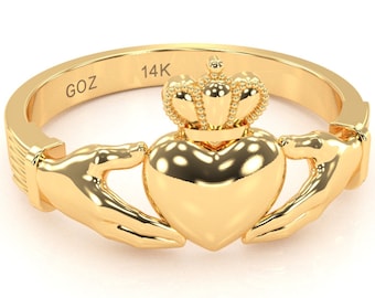 May include: A gold 14K Claddagh ring with a heart, two hands, and a crown on top. The inscription "GOZ" is visible on the band.