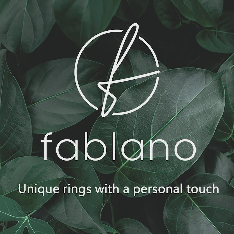 May include: The Fablano logo, a white stylized 'f' within a circle, is set against a backdrop of lush green leaves. Below, the brand name 'fablano' is displayed in white, with the tagline 'Unique rings with a personal touch'.