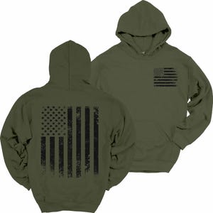 May include: A green hooded sweatshirt with a black distressed American flag design on the back and a smaller version of the flag on the front left chest.