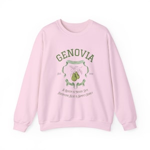 May include: Pink sweatshirt with a green graphic print of a crest with the text "GENOVIA" and the years "1881" and "2001". The crest also includes a drawing of two pears and the text "A Queen is "Never Late" Everyone Else is Simply Early".