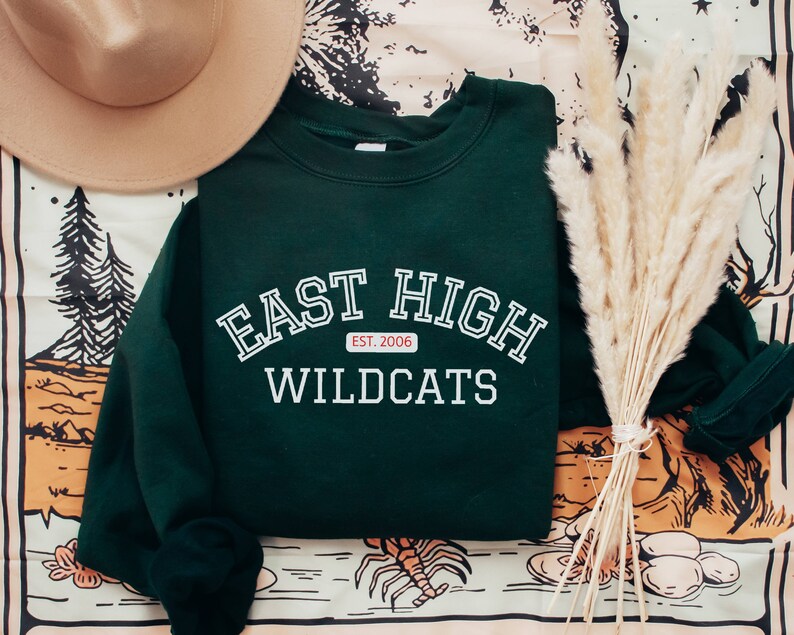 May include: A dark green sweatshirt with white text that reads "East High Wildcats" and a small red tag that says "Est. 2006".