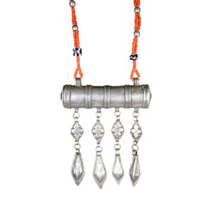 May include: A necklace featuring a cylindrical silver-toned metal pendant with four dangling diamond-shaped charms. The chain consists of small orange beads interspersed with silver-toned beads and two black beads with white dots on each side.