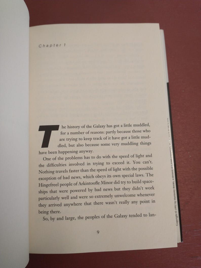Puede incluir: Un libro con una cubierta blanca y texto negro. El t&iacute;tulo del libro es "Cap&iacute;tulo 1". El texto de la p&aacute;gina trata sobre la historia de la Galaxia y la velocidad de la luz.