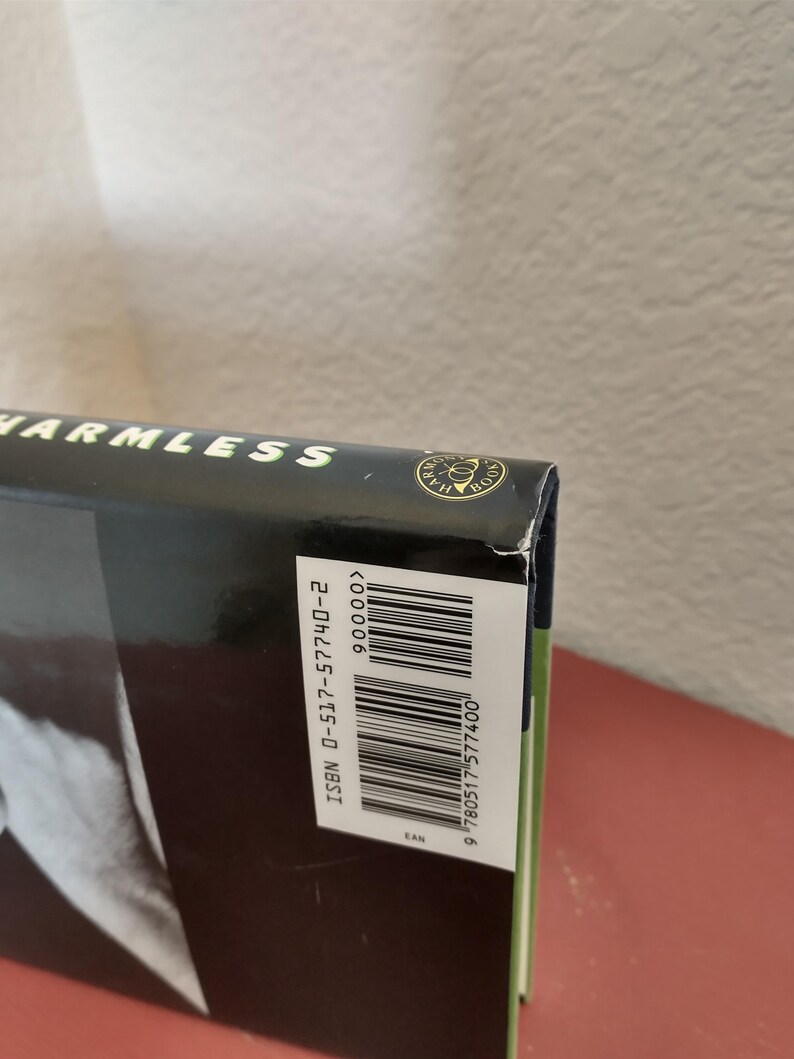 Puede incluir: Un libro negro de tapa dura con el t&iacute;tulo "HARMLESS" en la portada. El libro tiene un c&oacute;digo de barras y un n&uacute;mero ISBN en la contraportada. El n&uacute;mero ISBN es 0-517-57740-2.