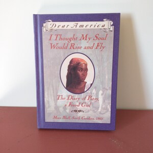 May include: A hardcover book titled "Dear America: I Thought My Soul Would Rise and Fly." The cover features a portrait of a Black woman and the text "The Diary of Patsy, a Freed Girl, Mars Bluff, South Carolina, 1865."